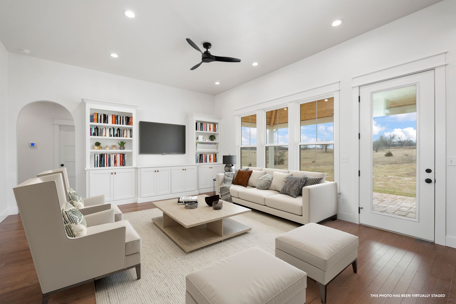 A living room with a couch , chairs , coffee table and television.