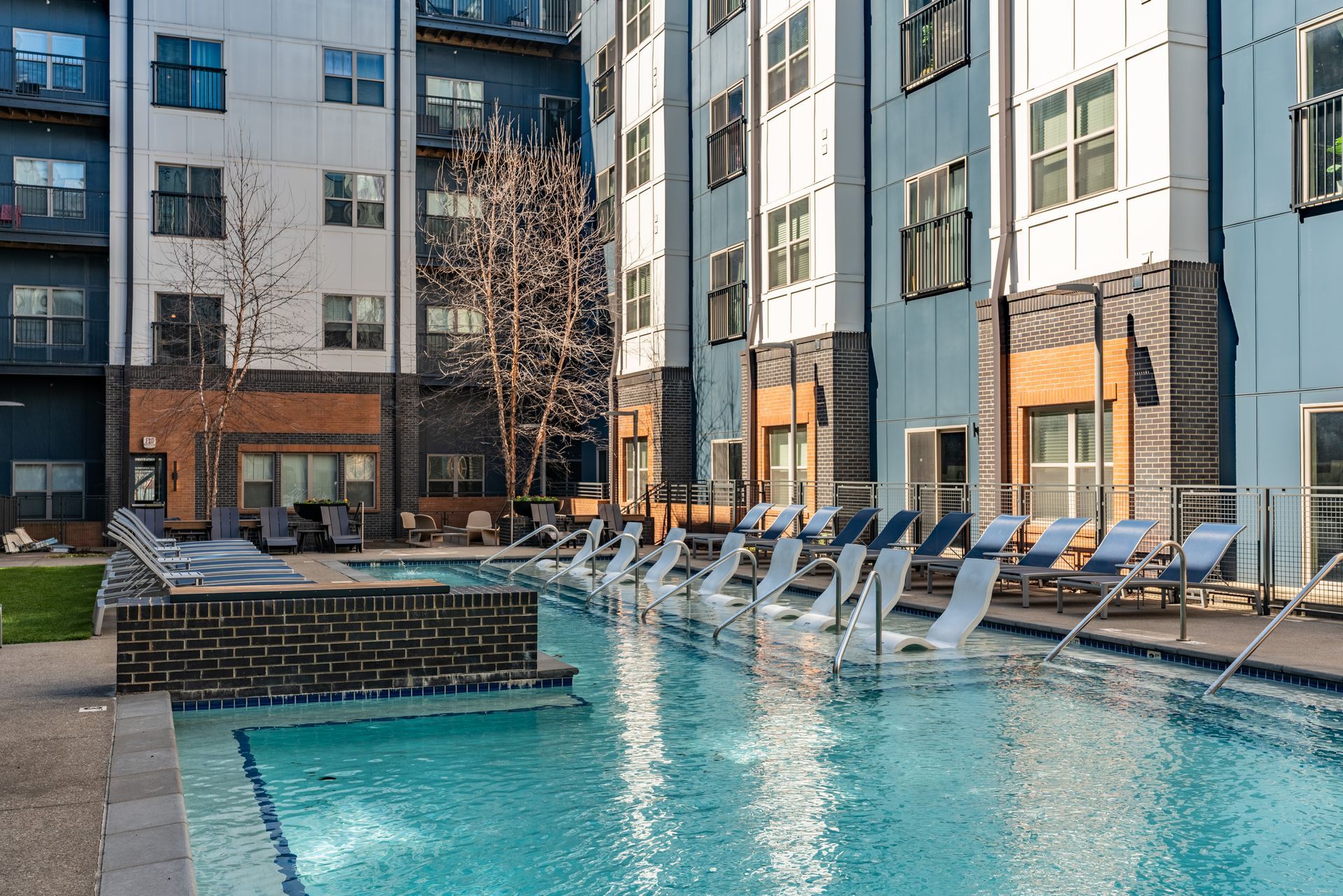 There is a large swimming pool in the middle of a building.