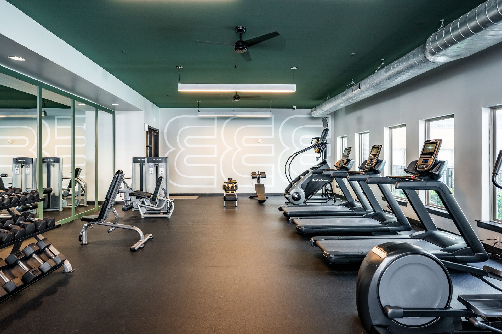 A gym with a lot of equipment and a large mirror.