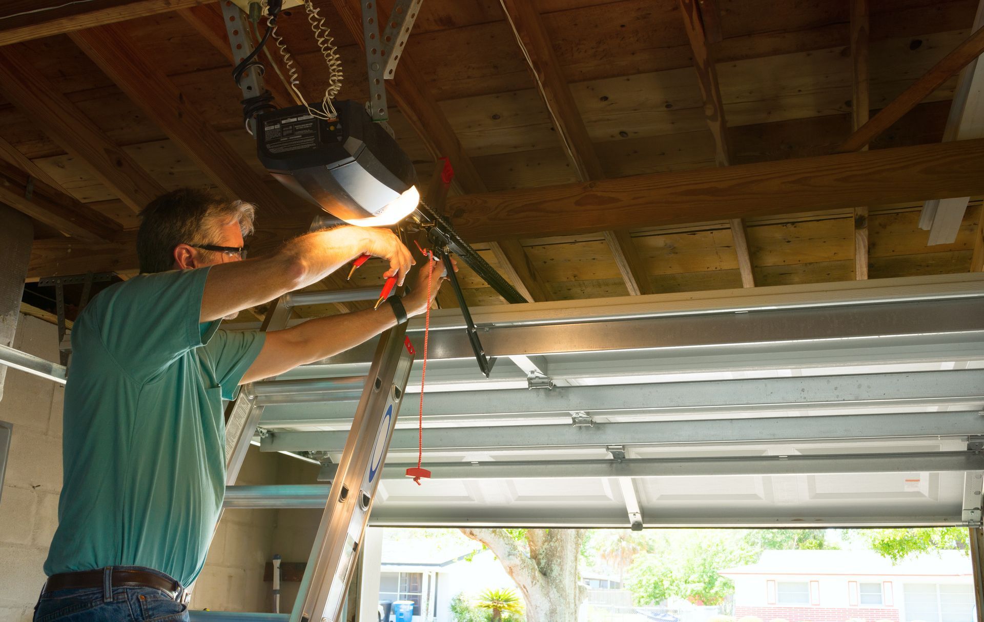 An automatic garage door opener repair service technician is working.