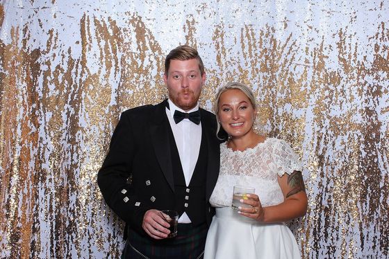 Married couple posing for a customized wedding photo booth rental