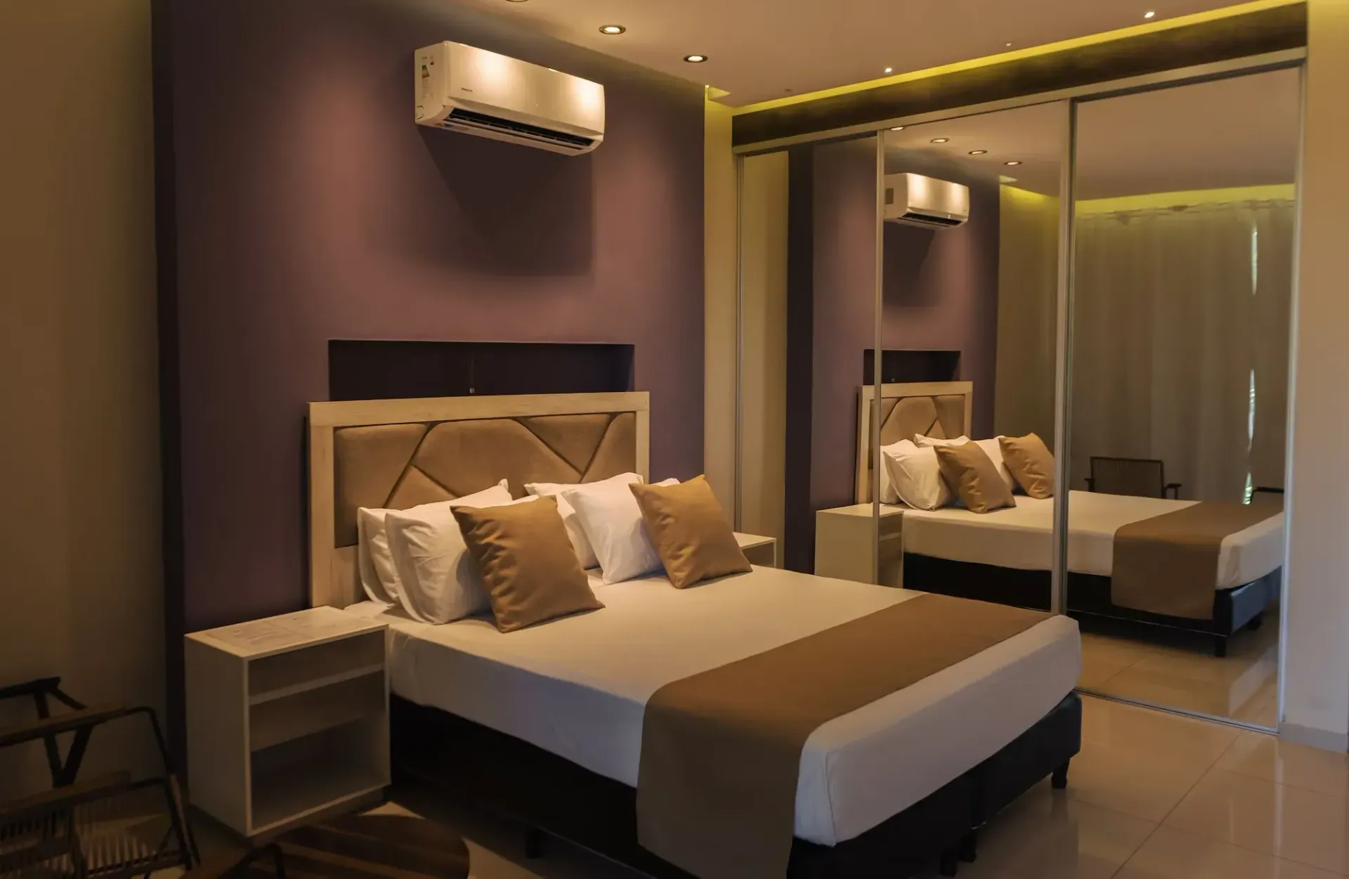 A bedroom with a large bed and a purple wall