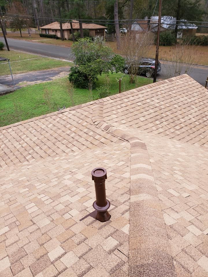Brick roof with a vent pipe, overlooking a suburban street and yard