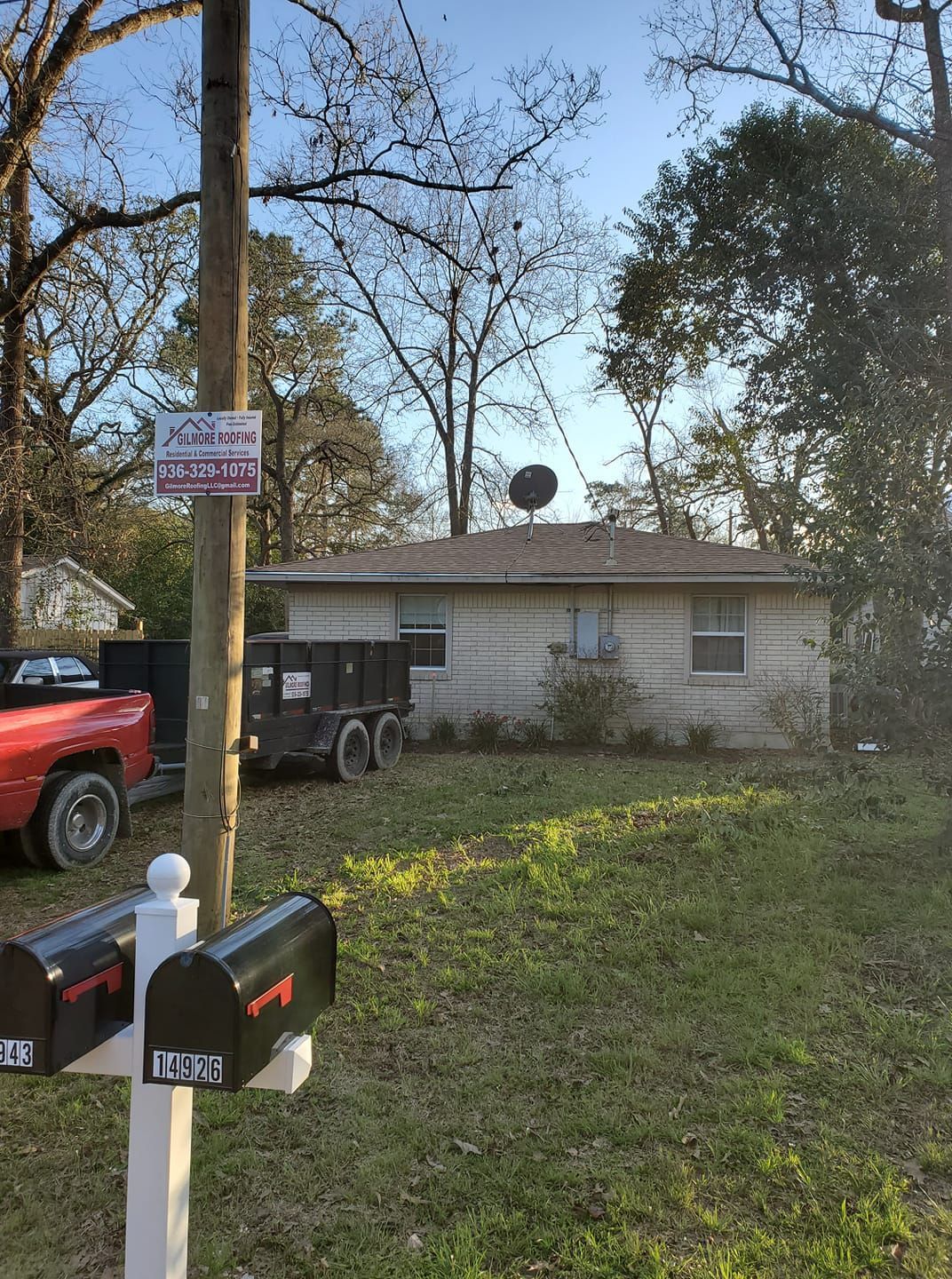Small white house with a satellite dish, mailbox in foreground, and a red truck parked beside it.