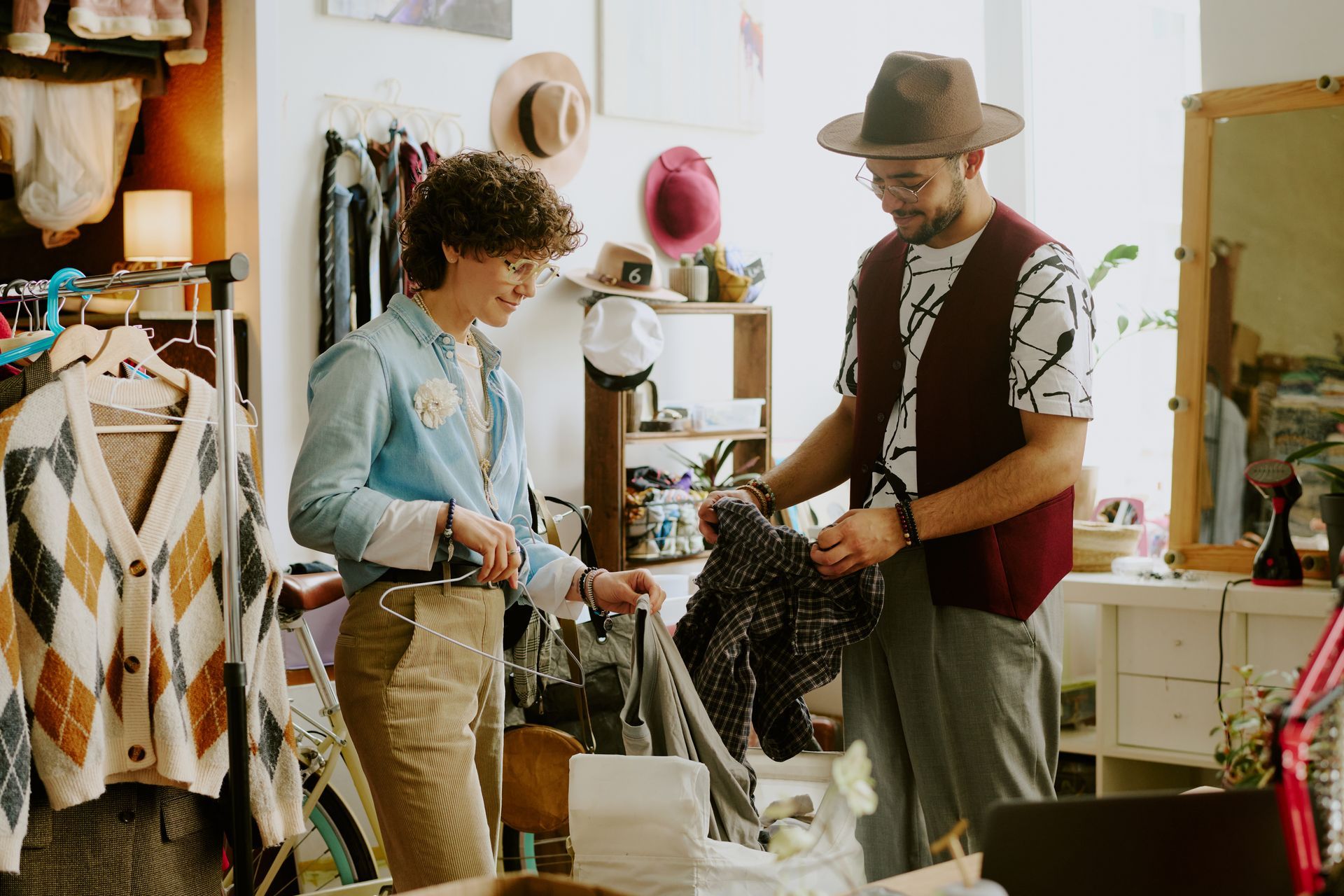 Two people shopping in a vintage clothing store, looking at a garment.