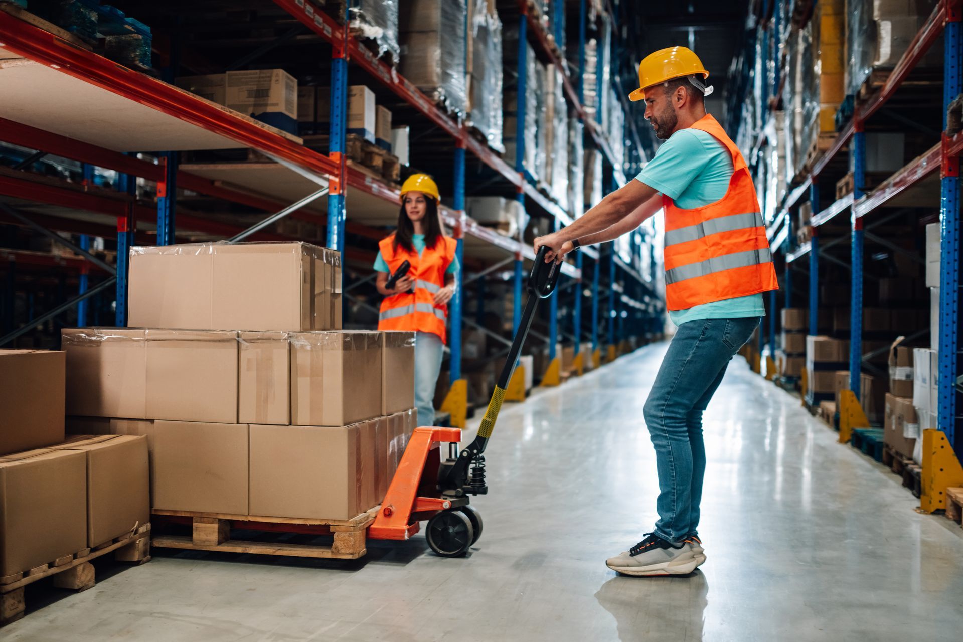 Warehouse workers loading boxes on a pallet jack in a warehouse.