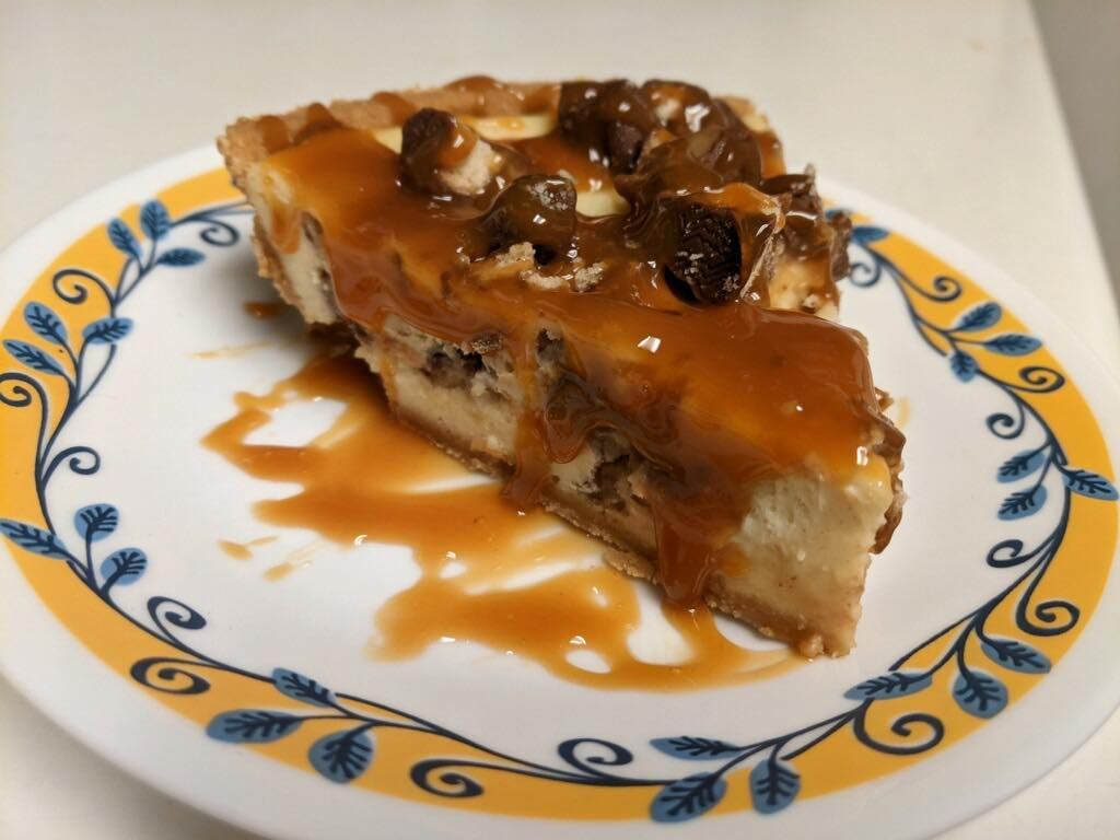 A slice of cheesecake on a plate with caramel sauce