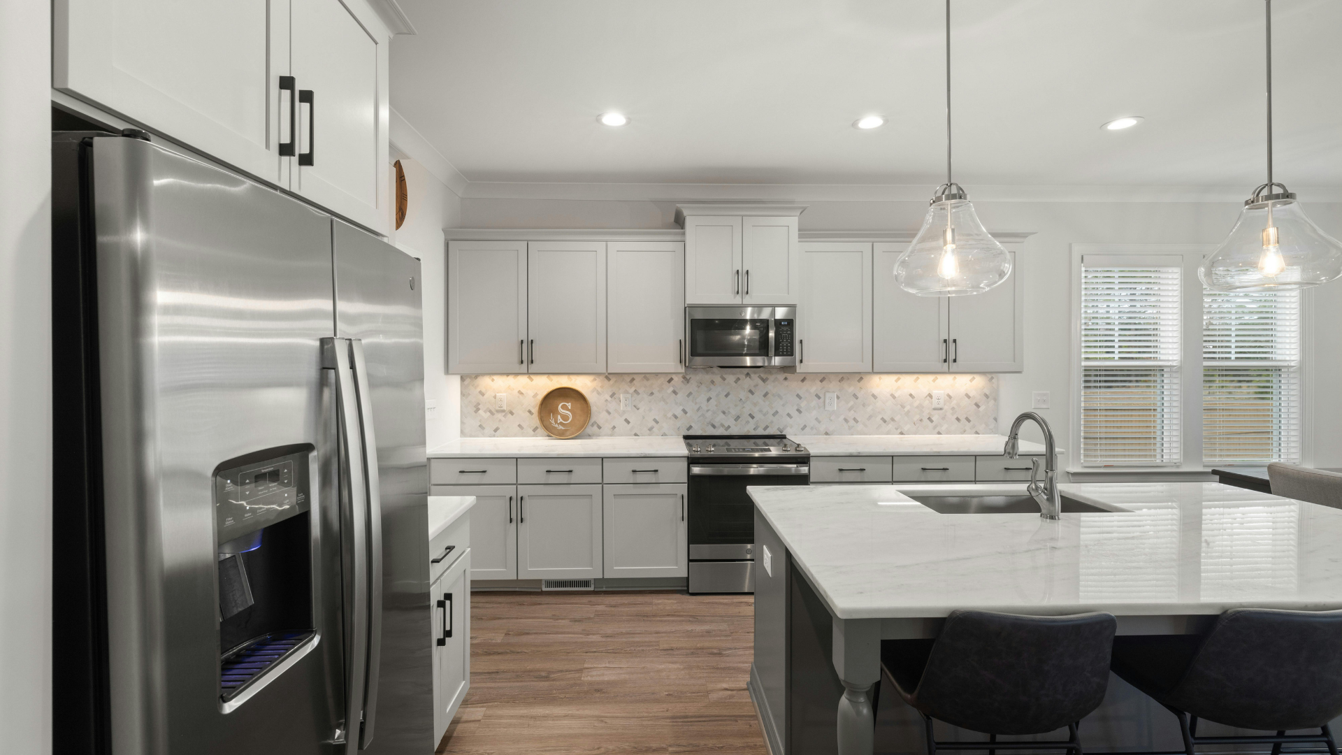 Modern kitchen with wood cabinets, stainless steel appliances, and island.