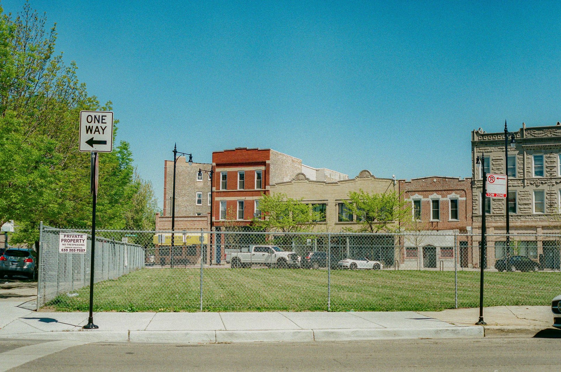 A white truck is parked in a parking lot next to a building.