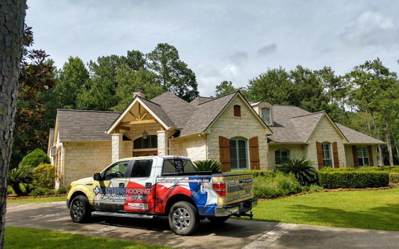A truck is parked in front of a large house.
