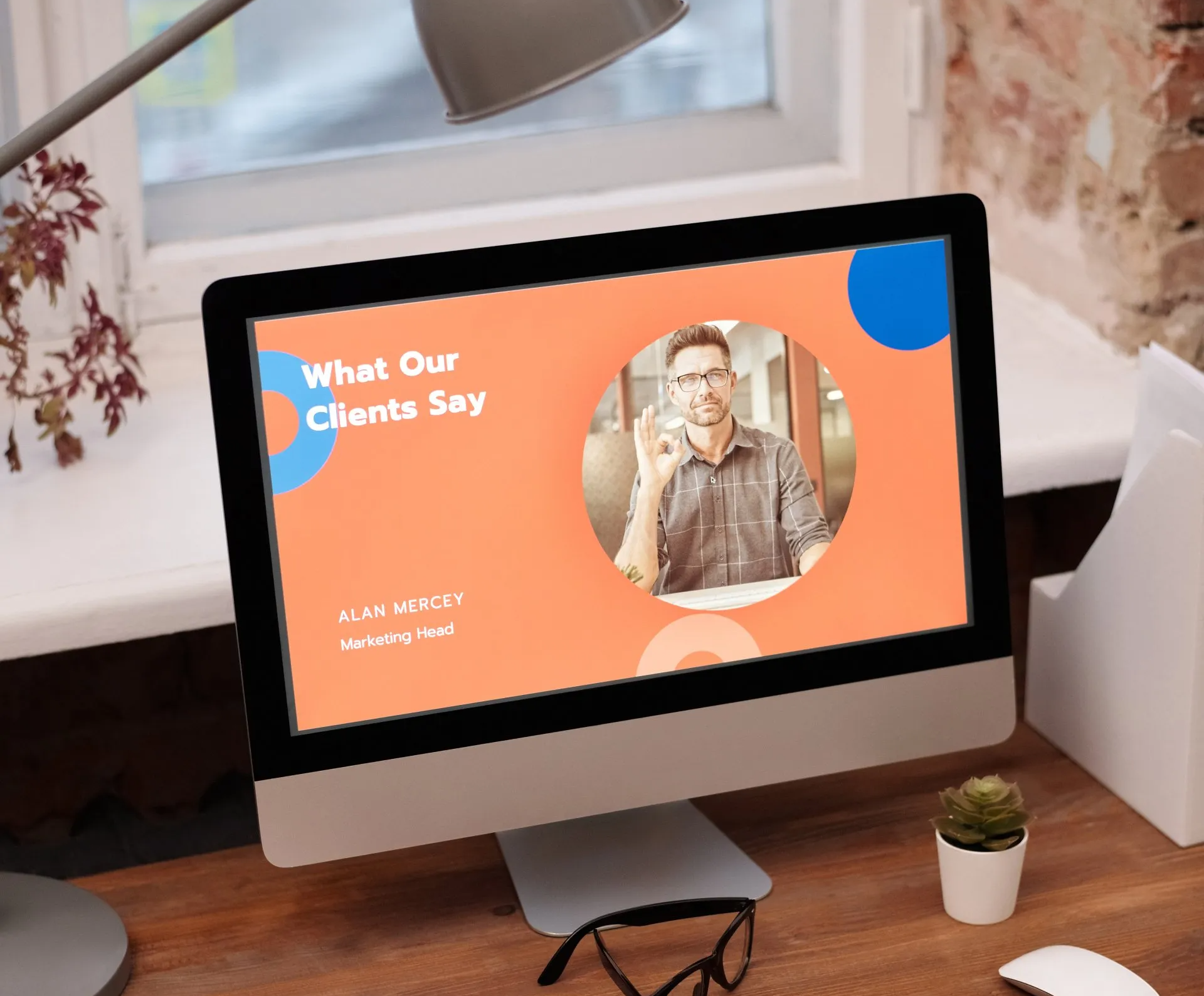 Desktop monitor showing a “What Our Clients Say” testimonial slide with a portrait on an orange background