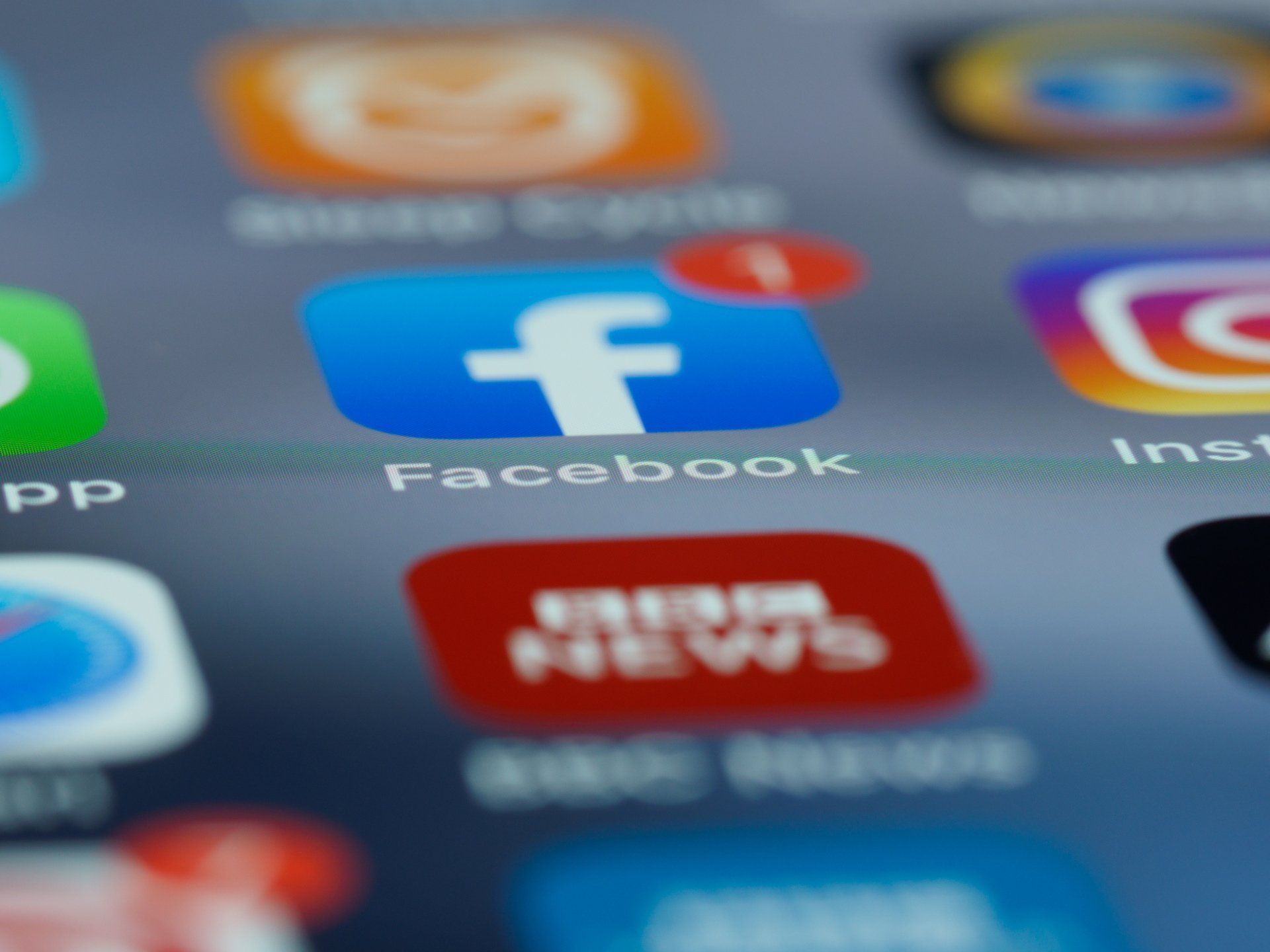 Close-up of social media app icons on a smartphone screen, including Facebook, Instagram, and Twitter.