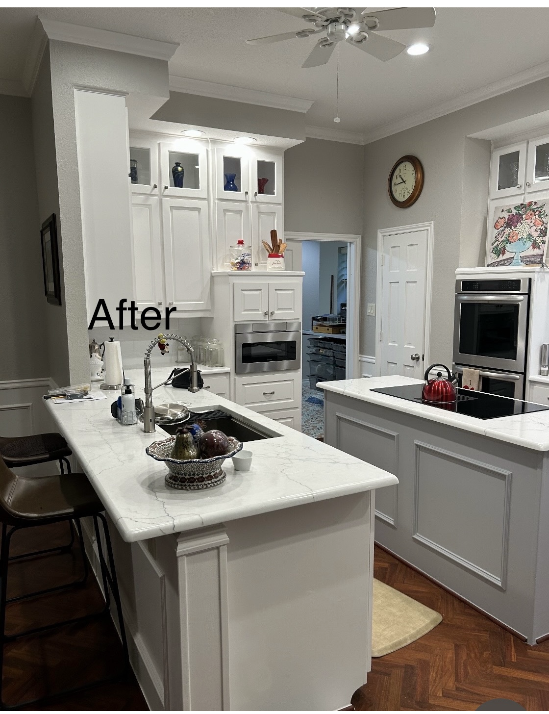A Kitchen with White Cabinets , Granite Counter Tops , a Sink , and A Ceiling Fan.