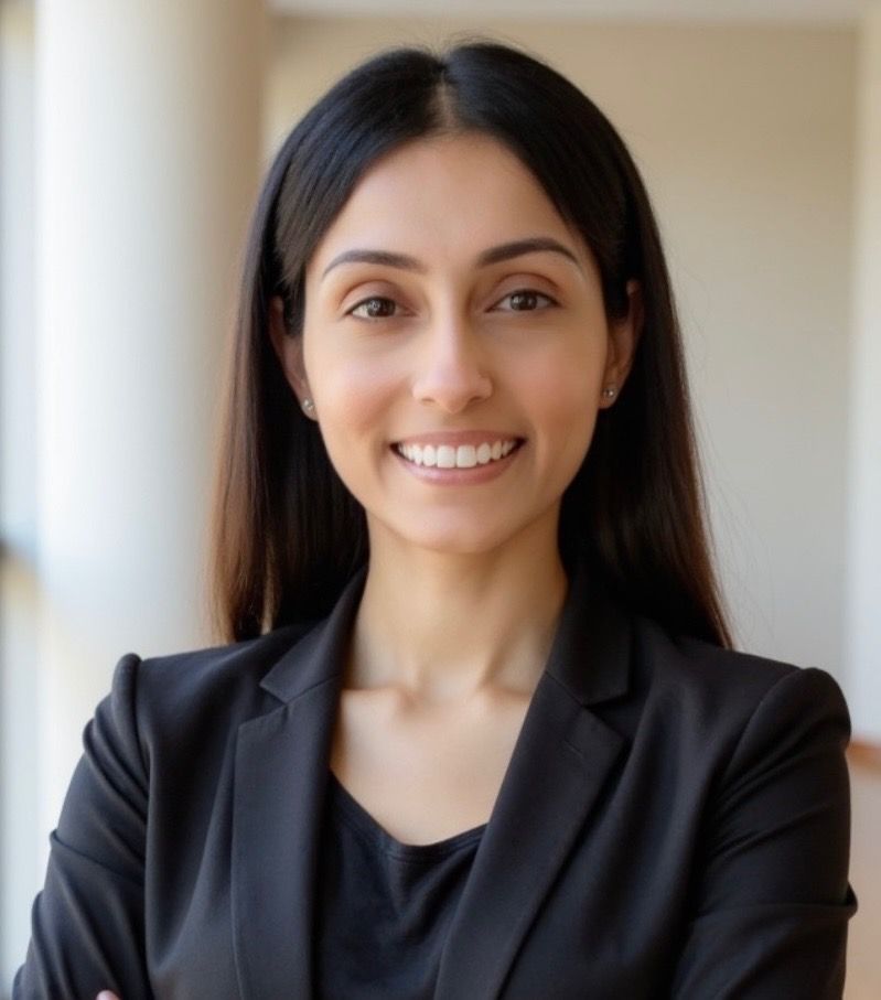 Smiling professional in a black blazer against a softly blurred indoor background