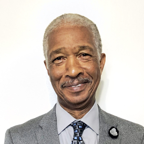 A man in a suit and tie is smiling for the camera