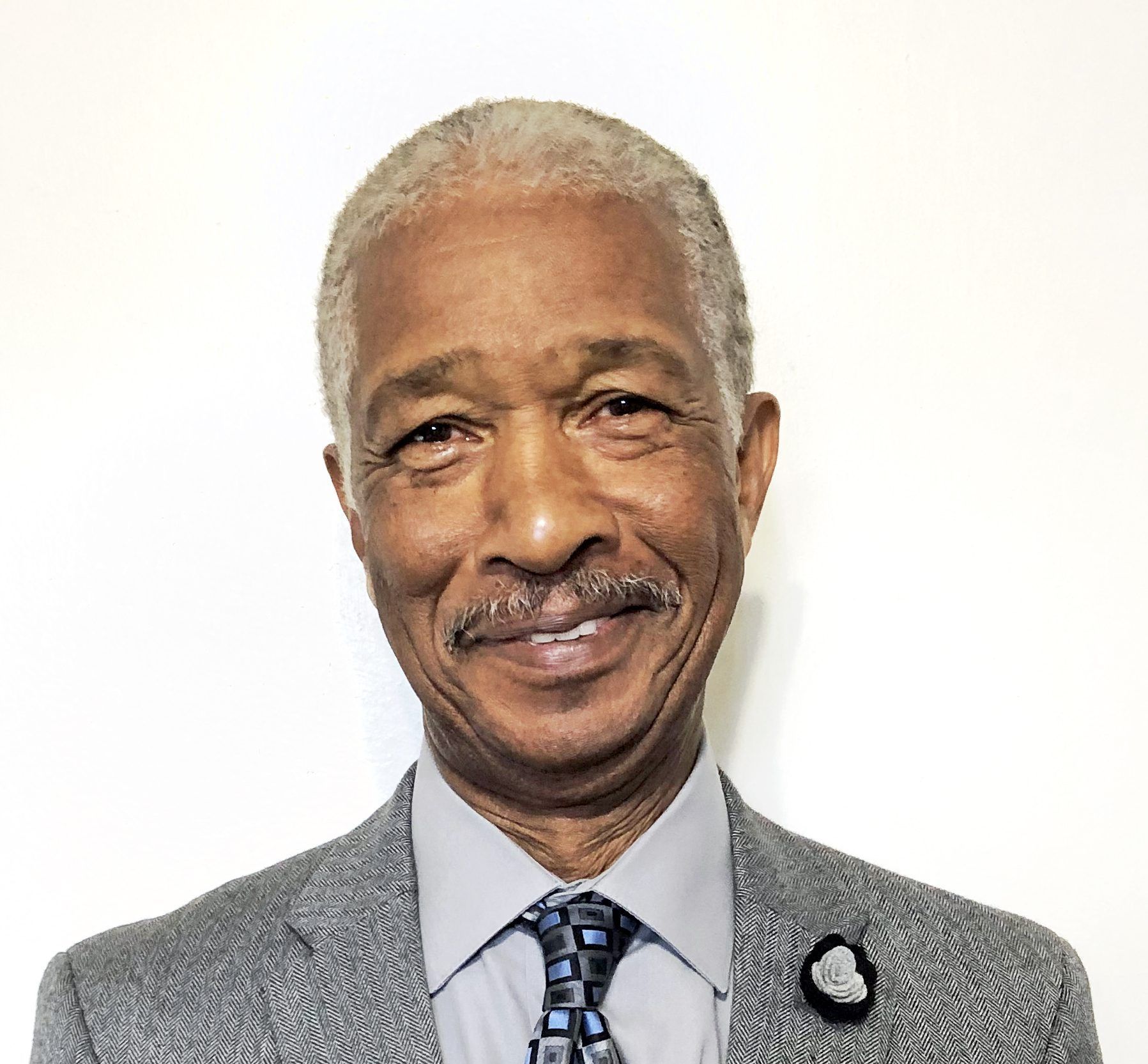A man in a suit and tie is smiling for the camera