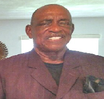 A man in a purple suit is smiling for the camera.