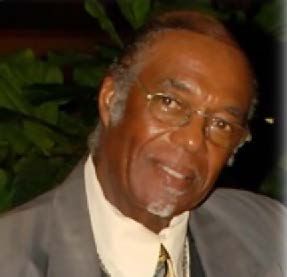 A man in a suit and tie is smiling for the camera.