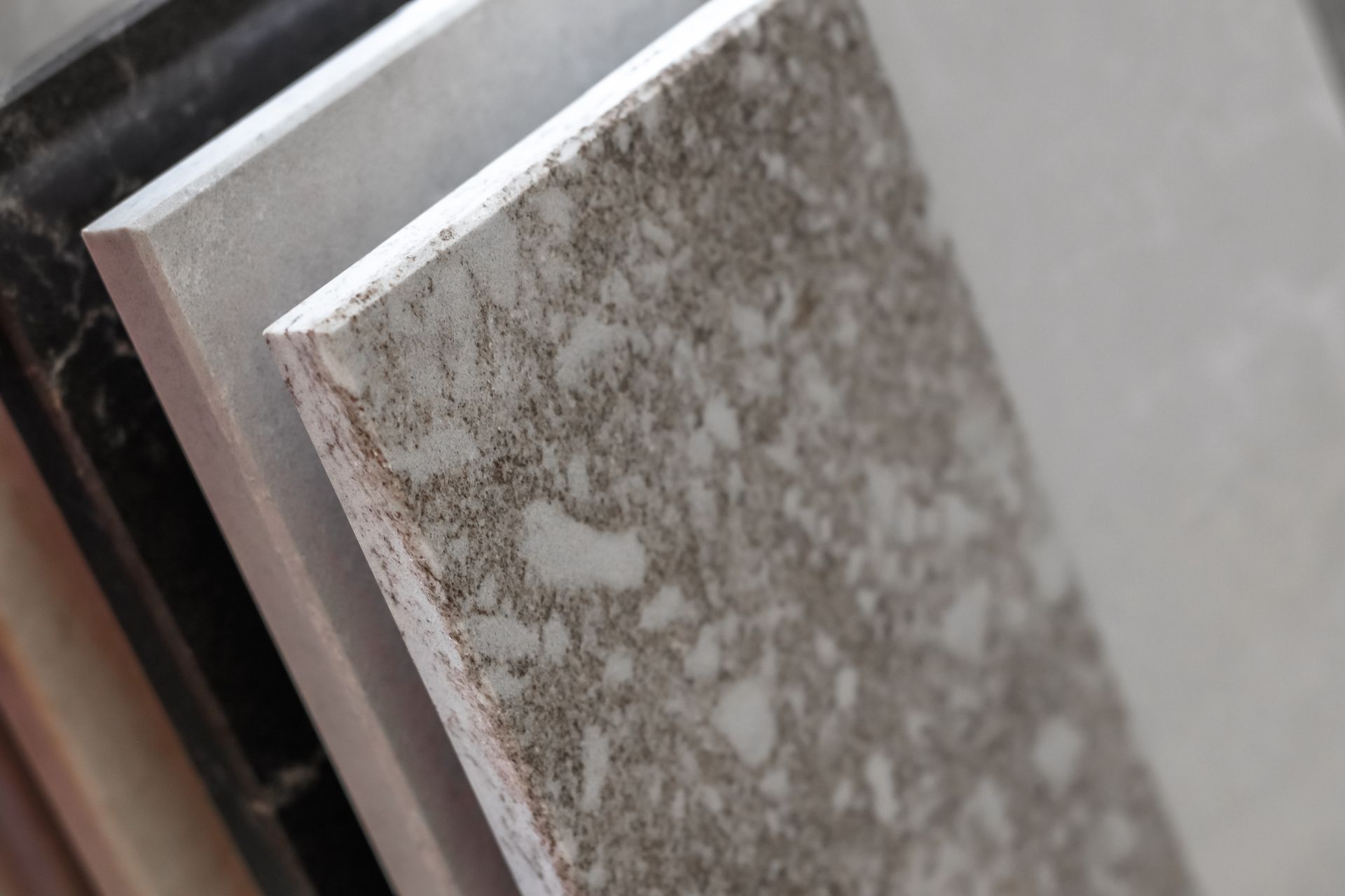 Close-up of stone and ceramic tile samples displayed in a showroom rack.