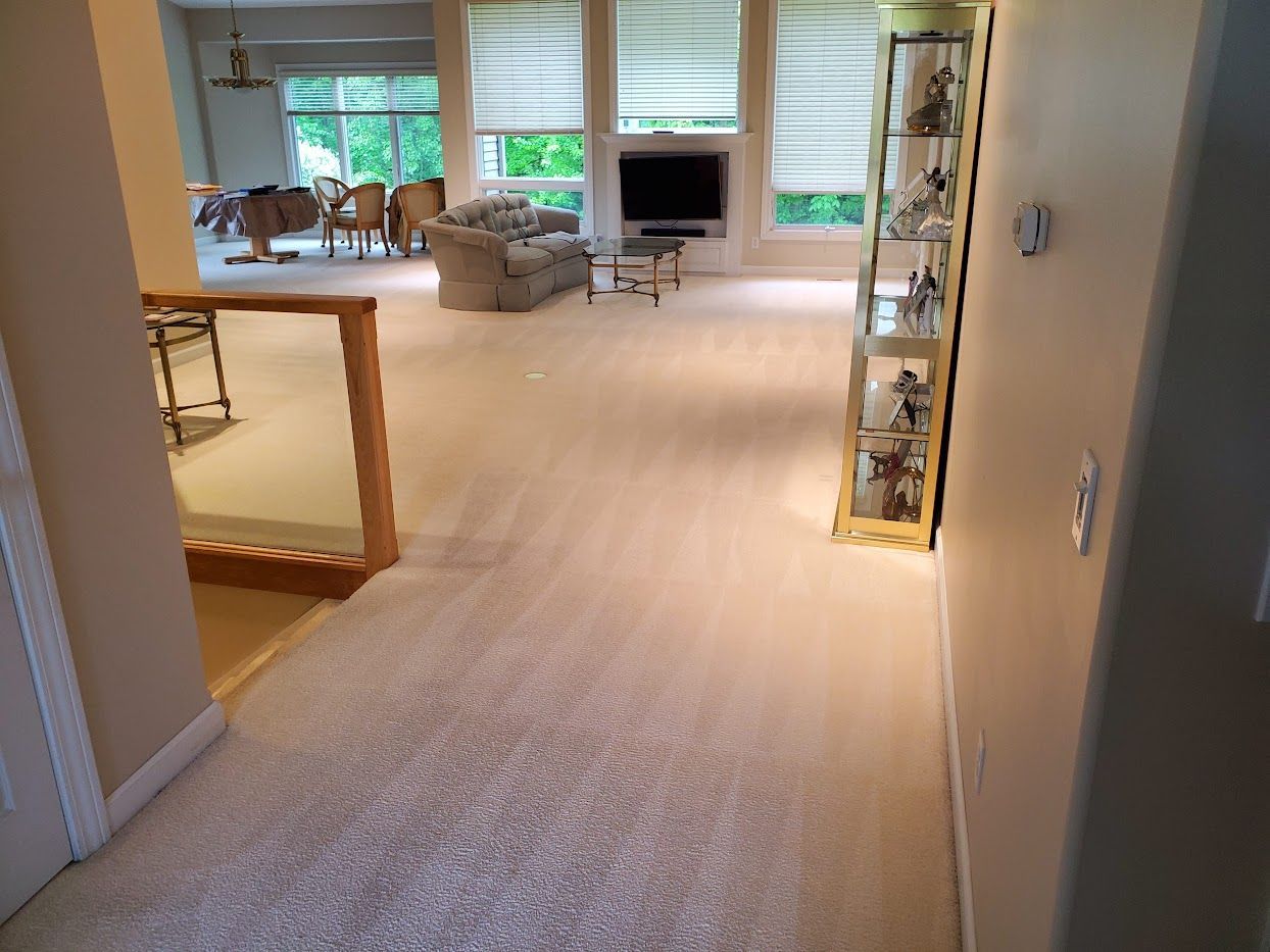Strongarm Cleaners - A living room with a carpeted floor and a staircase leading to the second floor.