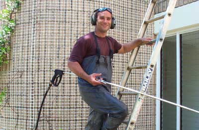 A Man Using A Power Washing Equipment — Pressure Cleaning in Nambucca Valley, NSW