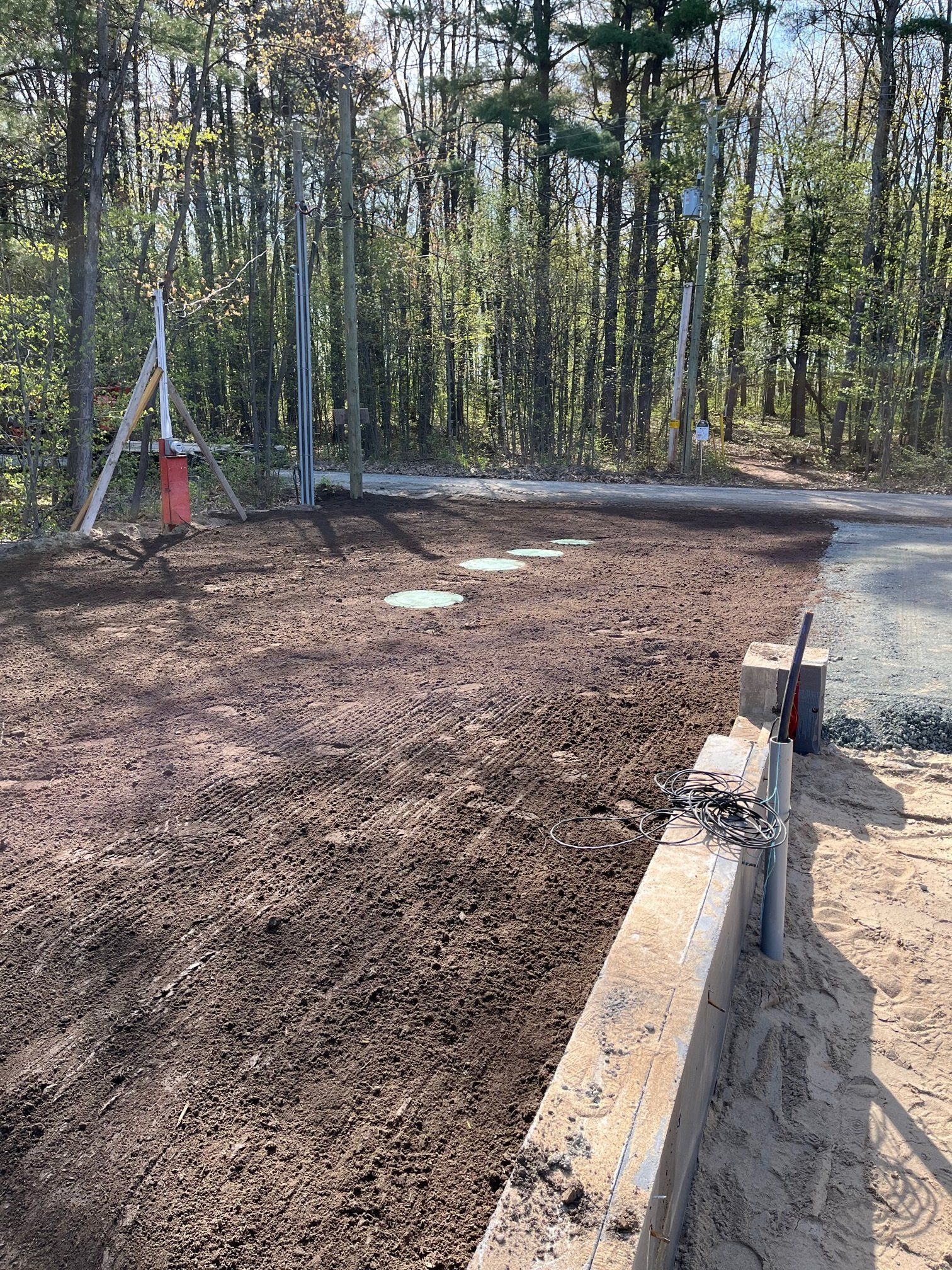 Un chemin de terre est en construction au milieu d'une forêt.
