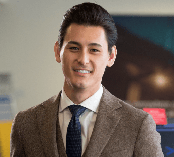 A man in a suit and tie is smiling for the camera.