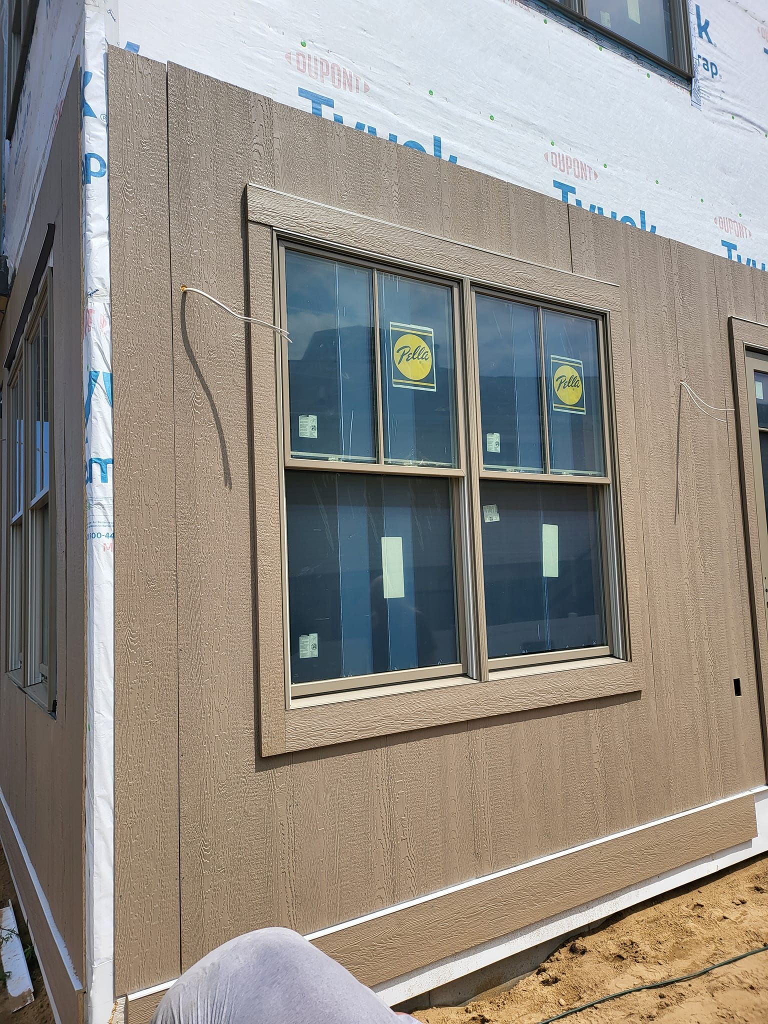 New stucco exterior wall with a window, likely at a construction site, under repair or finishing.