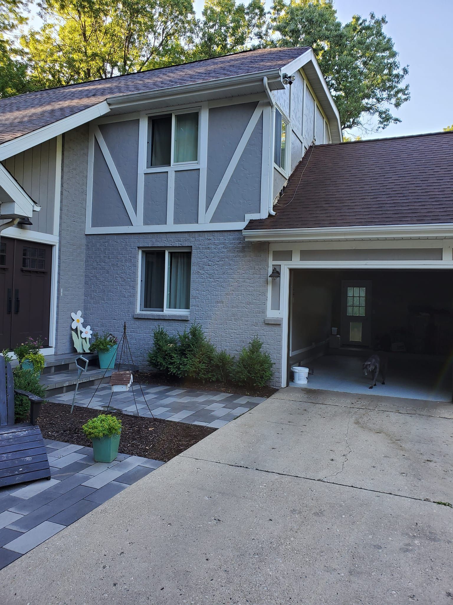 Suburban house exterior with a driveway, garage, and two-story facade with gray and white trim