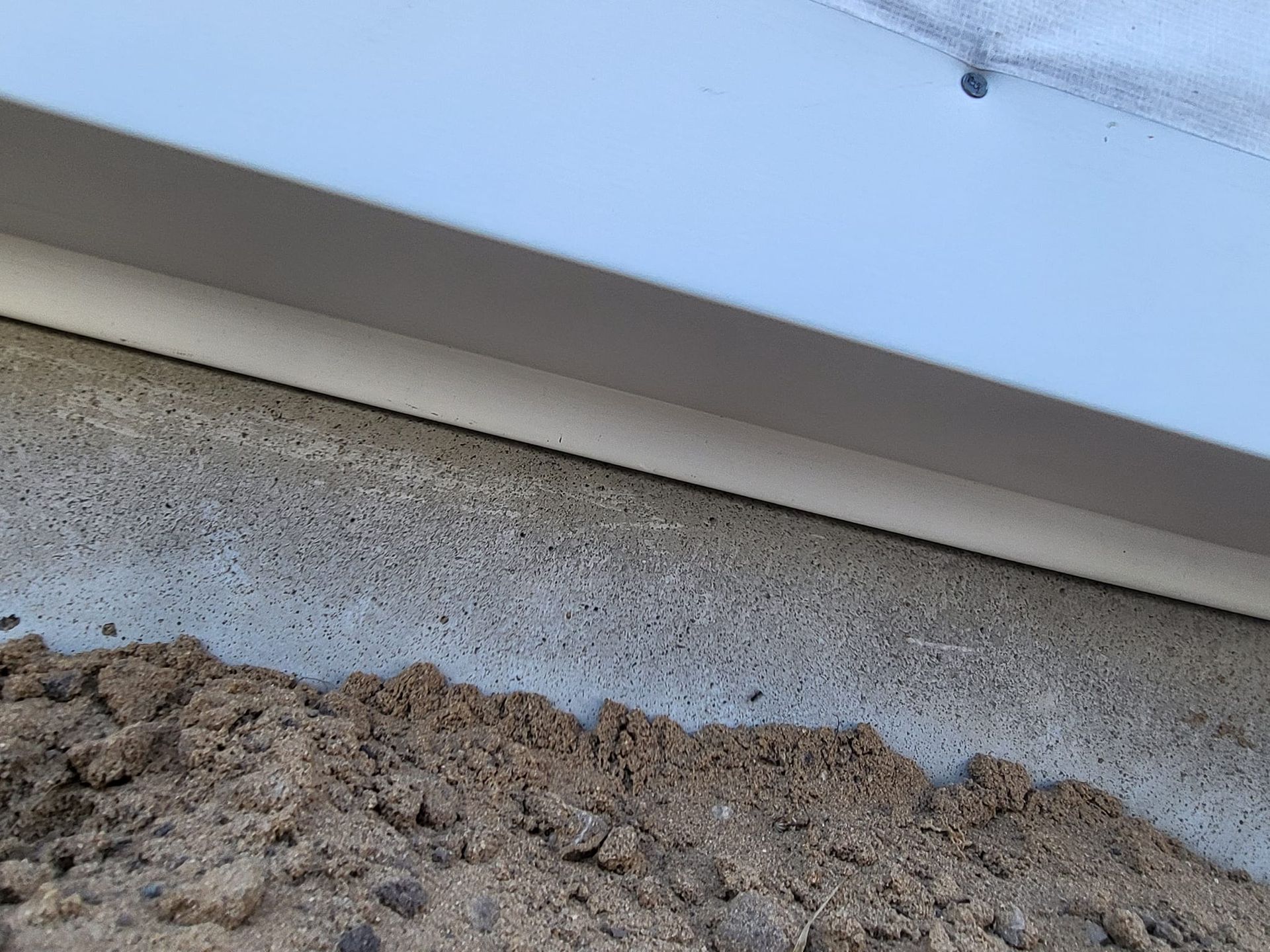 Close-up of a roof edge with a layer of dirt and debris along the gutter