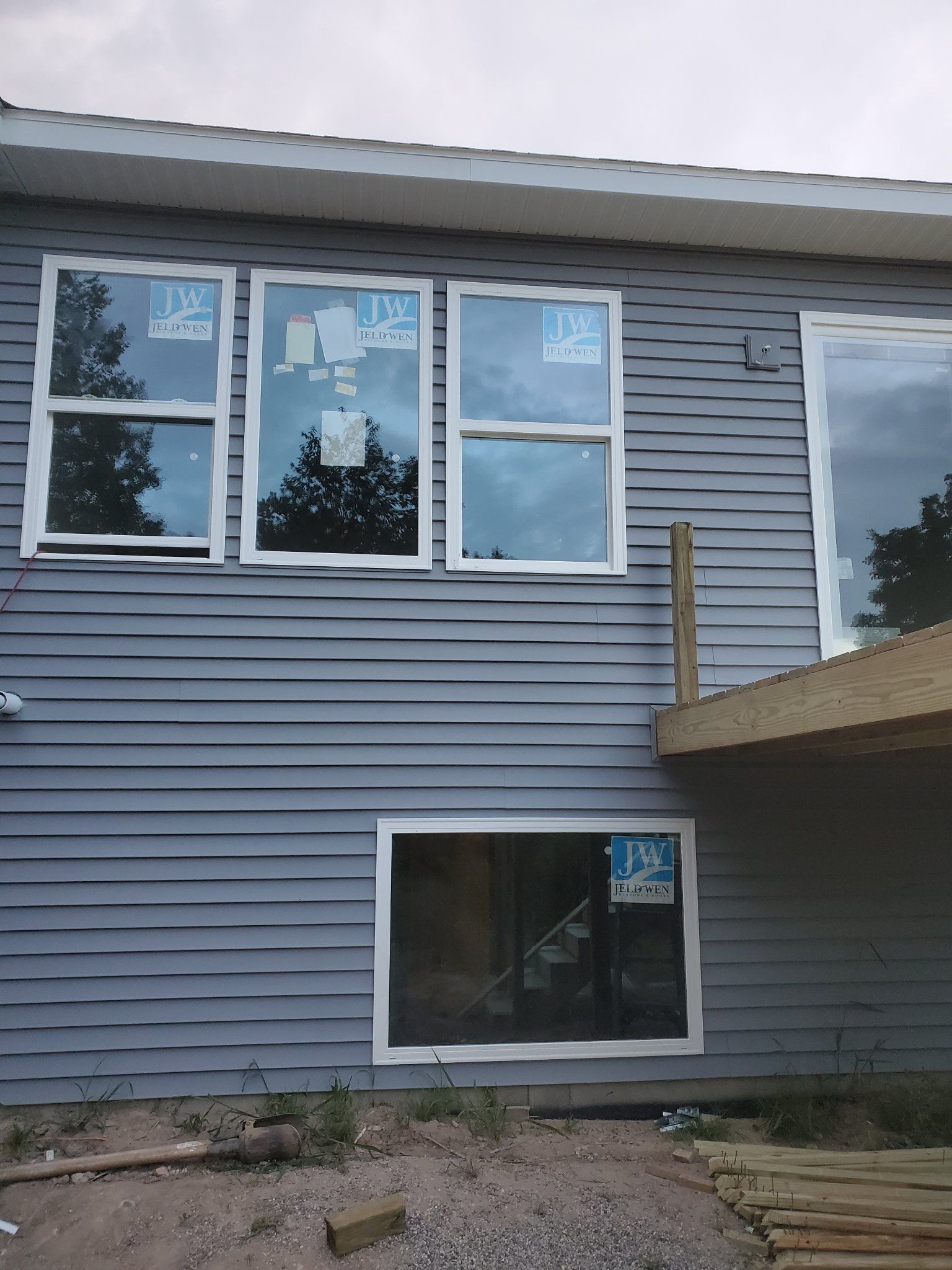 Exterior of a gray house with white-trimmed windows and an awning over a lower window