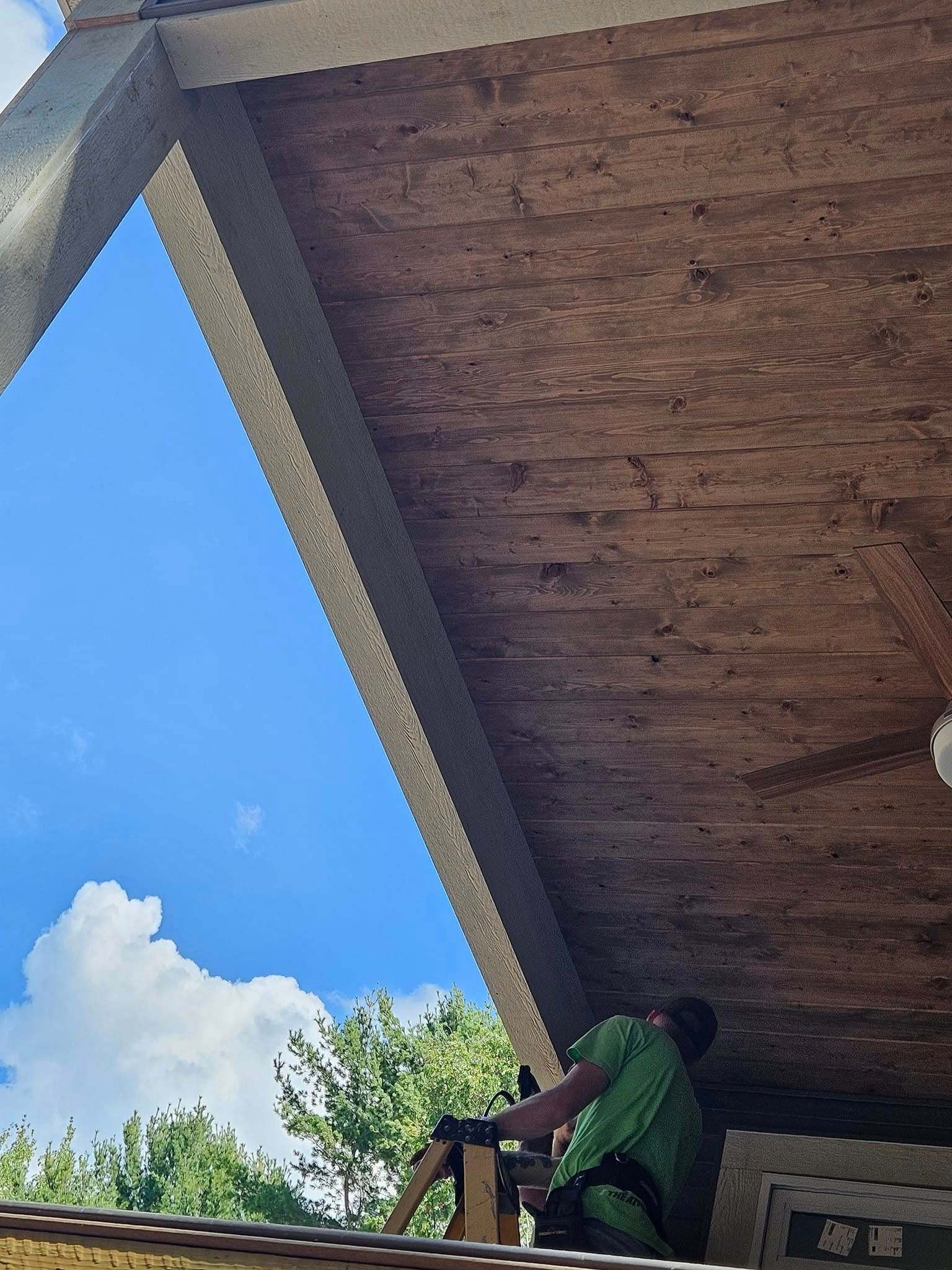 Person in a green shirt climbing under a concrete roof against a blue sky.