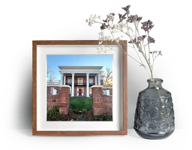 Entrance to Vincent Funeral Home with tall white pillars and red brick