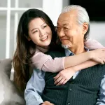 Smiling grandparent hugging grandchild