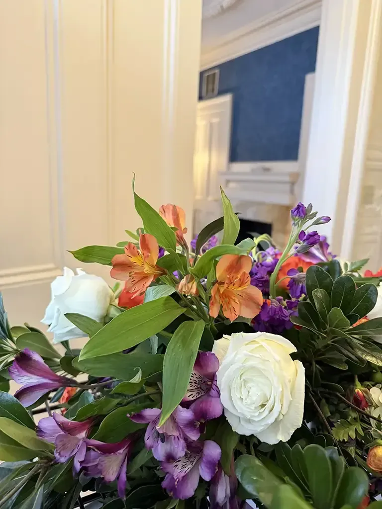 Bouquet of white, purple, and orange flowers in a bright indoor room