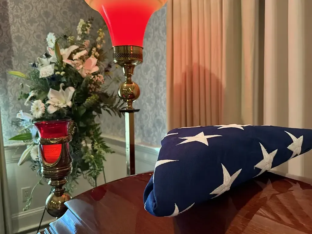 Close-up of wooden casket with folded American flag set on top