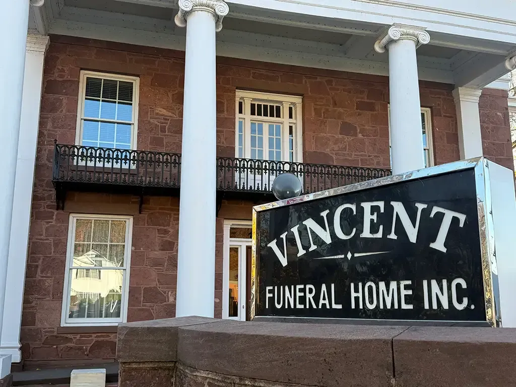 Vincent Funeral Home Inc. sign in front of a brick building with white columns