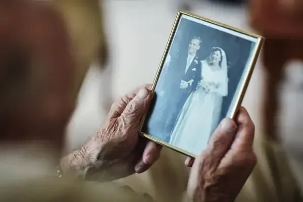 Hands holding a framed black-and-white wedding photo.