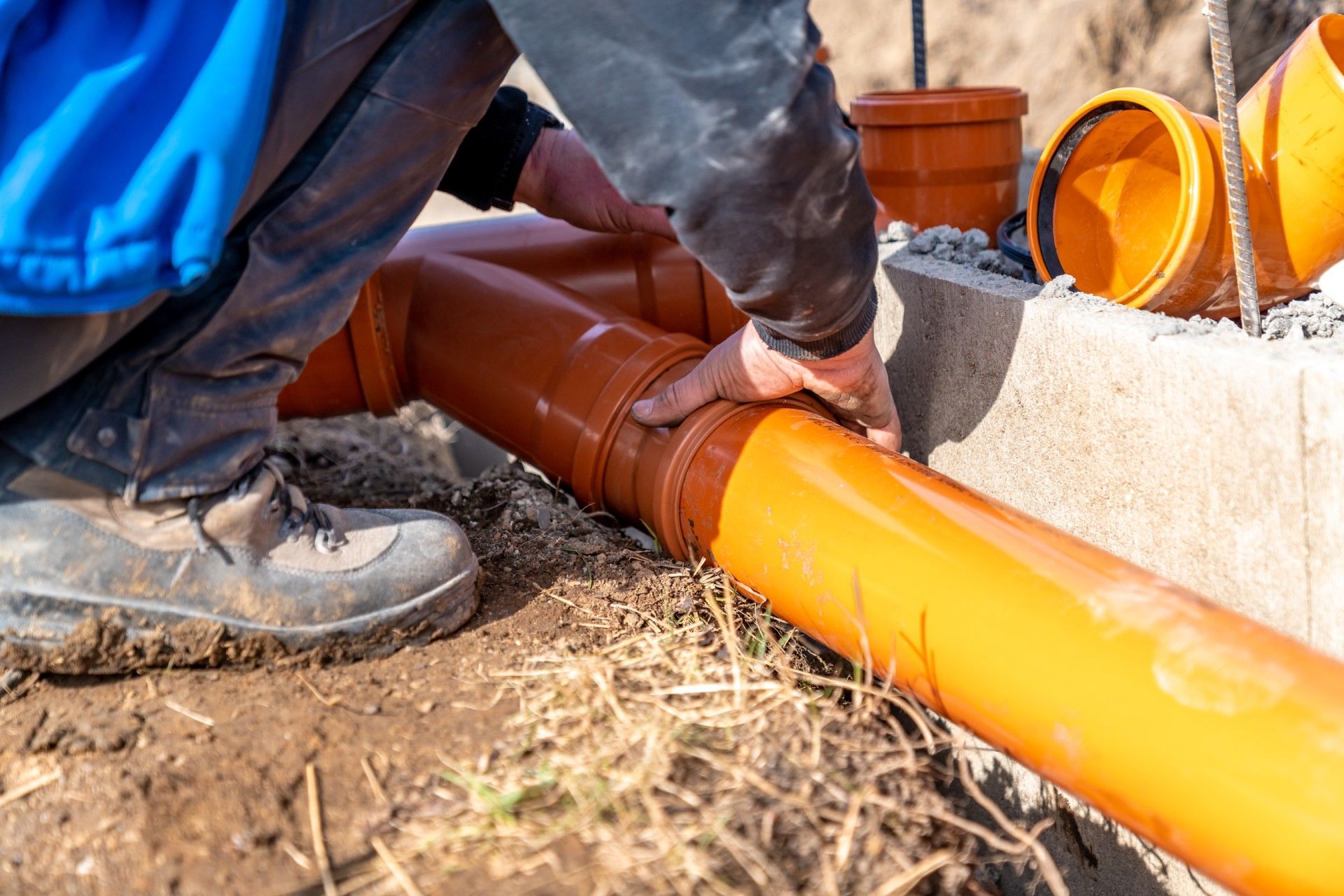 A man is installing a pipe in the ground.