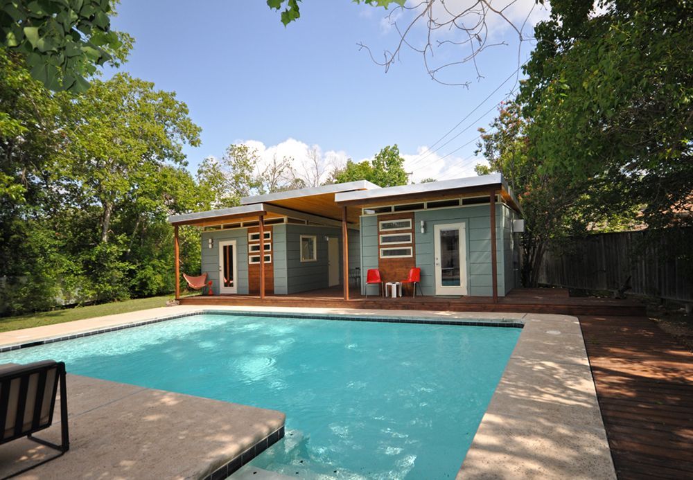 A house with a swimming pool in front of it