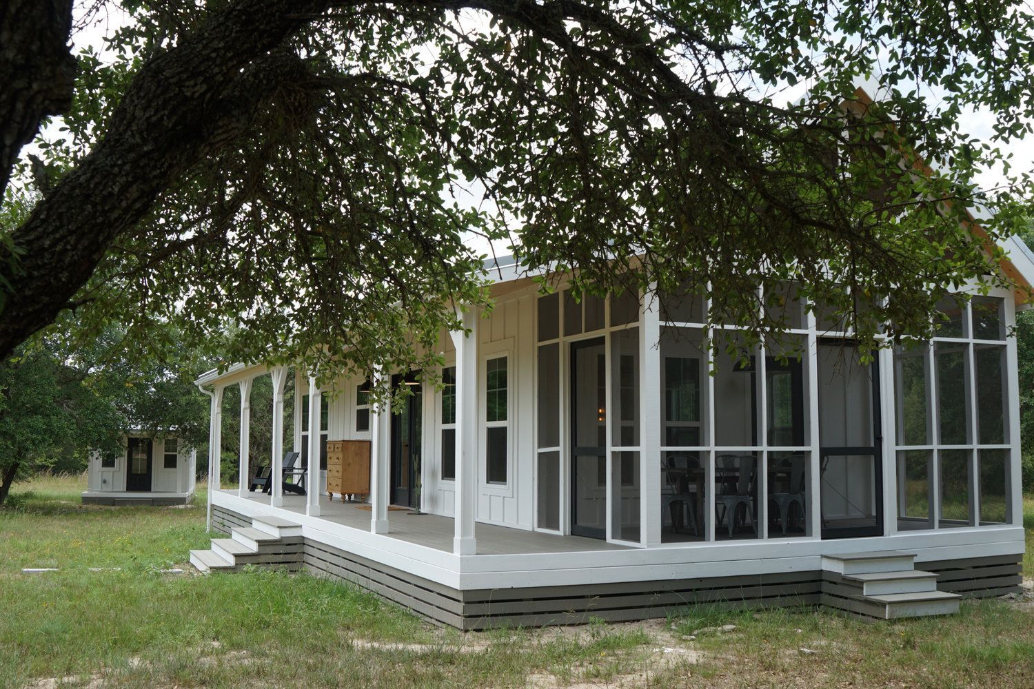 A white house with a screened in porch and stairs