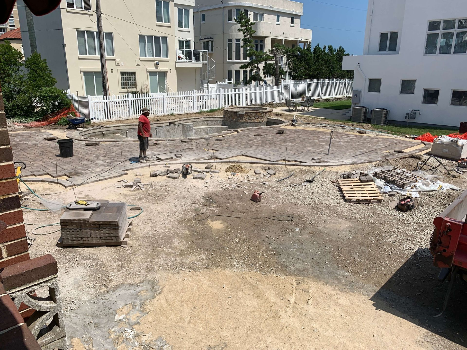 Construction site with rubble and debris between apartment buildings, with one person standing near the center.
