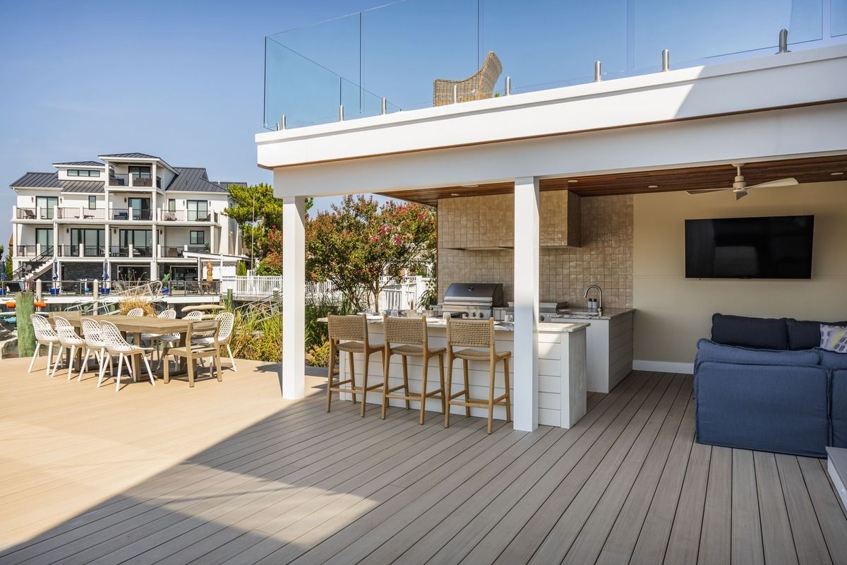 Rooftop terrace with outdoor dining area, bar seating, and blue sofa overlooking nearby buildings