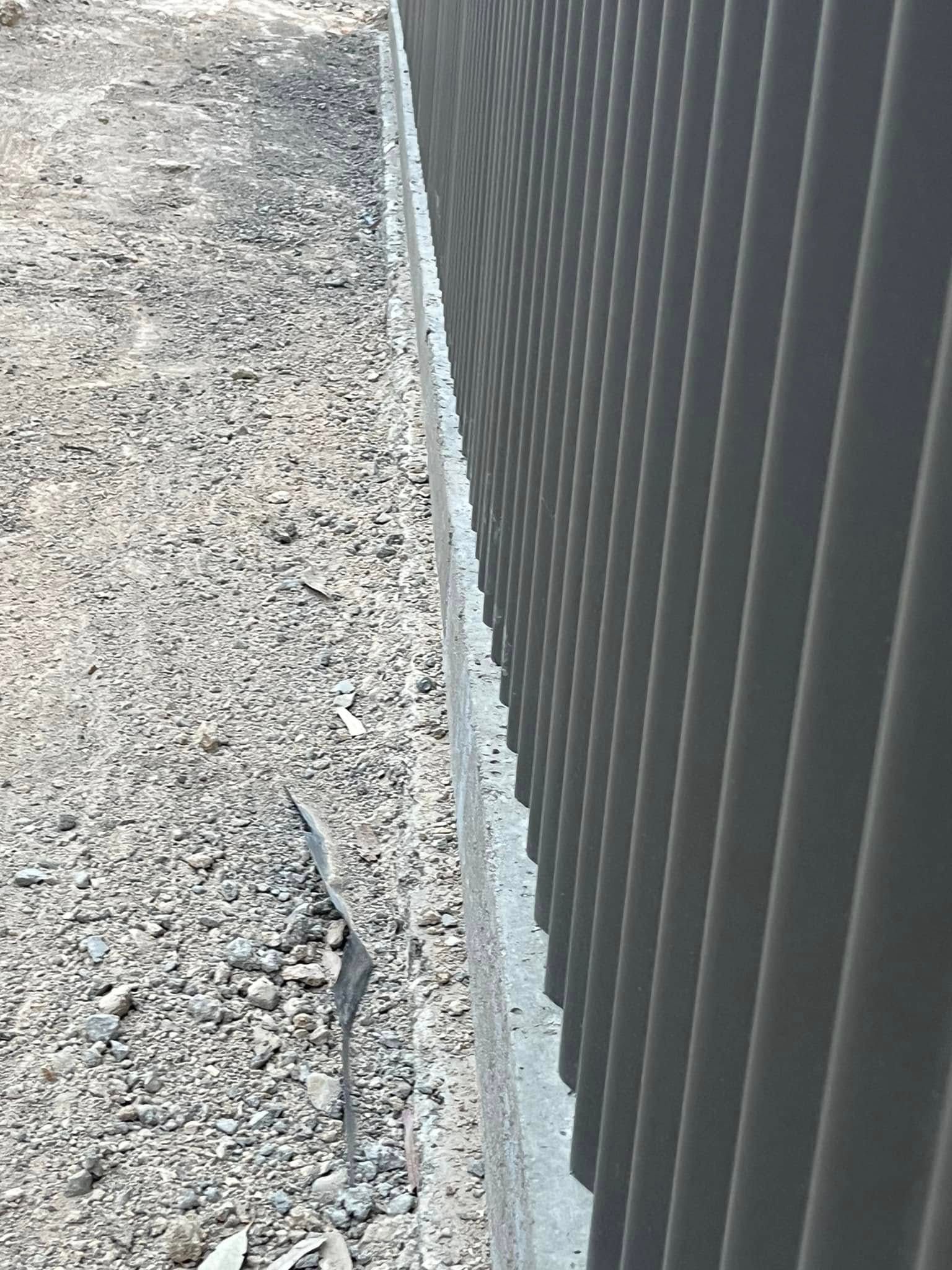 A Large Metal Garage Is Sitting in The Middle of A Lush Green Field — Next Level Construction Contractors in Gundagai, NSW