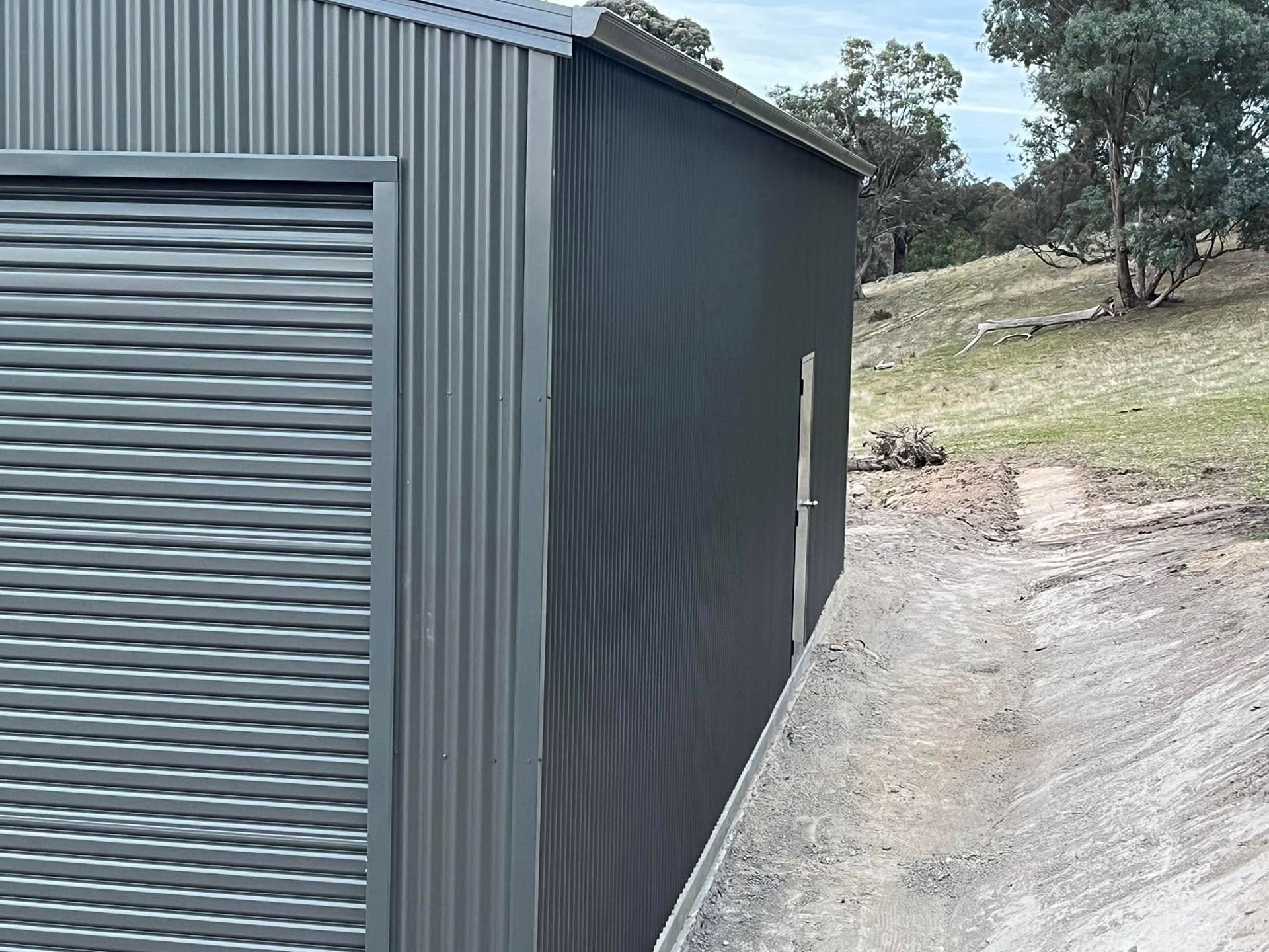 A Concrete Floor Is Being Built in A Backyard Next to A Green Fence — Next Level Construction Contractors in Gundagai, NSW