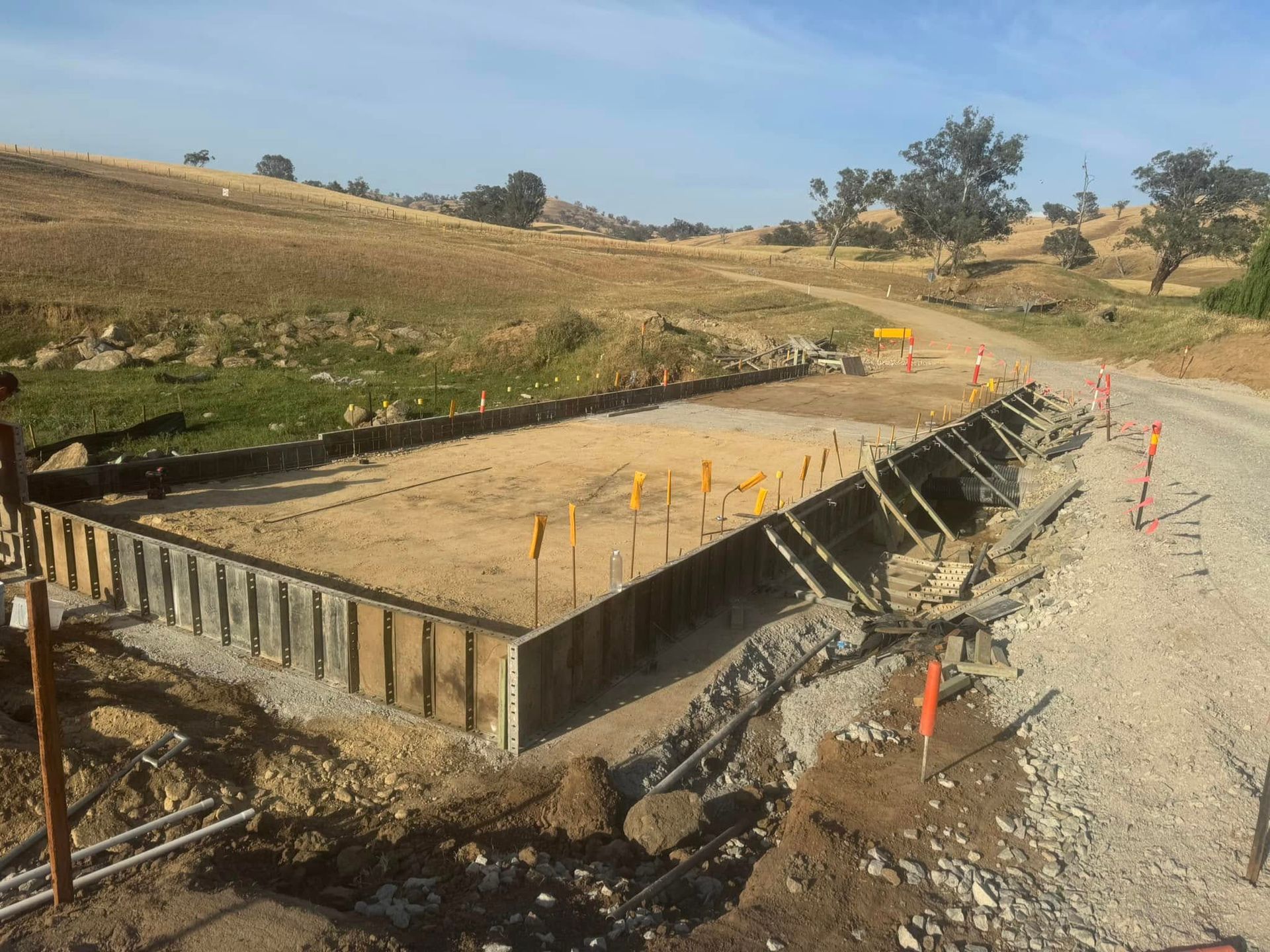 A Concrete Table is Sitting on the Shore of a Lake — Next Level Construction Contractors in Gundagai, NSW