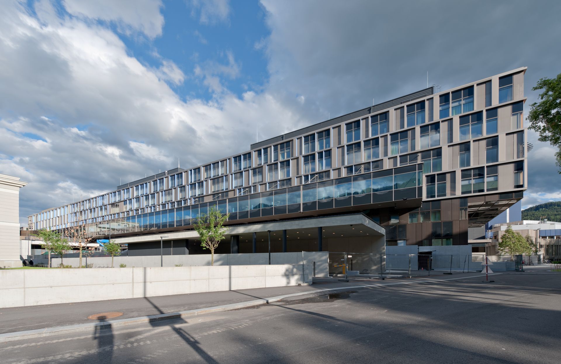 Am Straßenrand steht ein großes Gebäude mit vielen Fenstern.