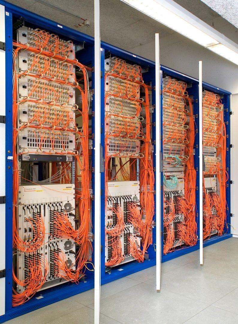 Eine Reihe von Server-Racks, aus denen orangefarbene Kabel herauskommen
