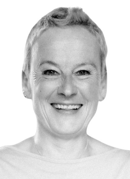 Ein Schwarzweißfoto einer lächelnden Frau, die eine Halskette trägt.