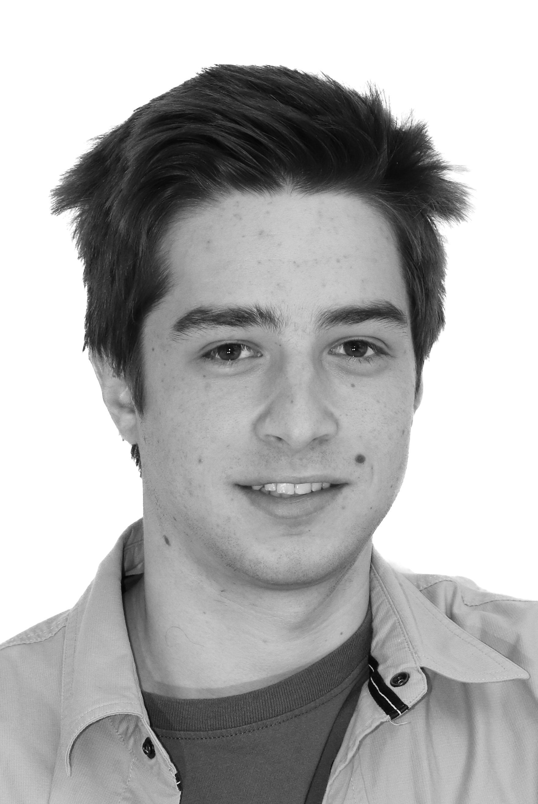 Ein junger Mann lächelt auf einem Schwarzweißfoto.